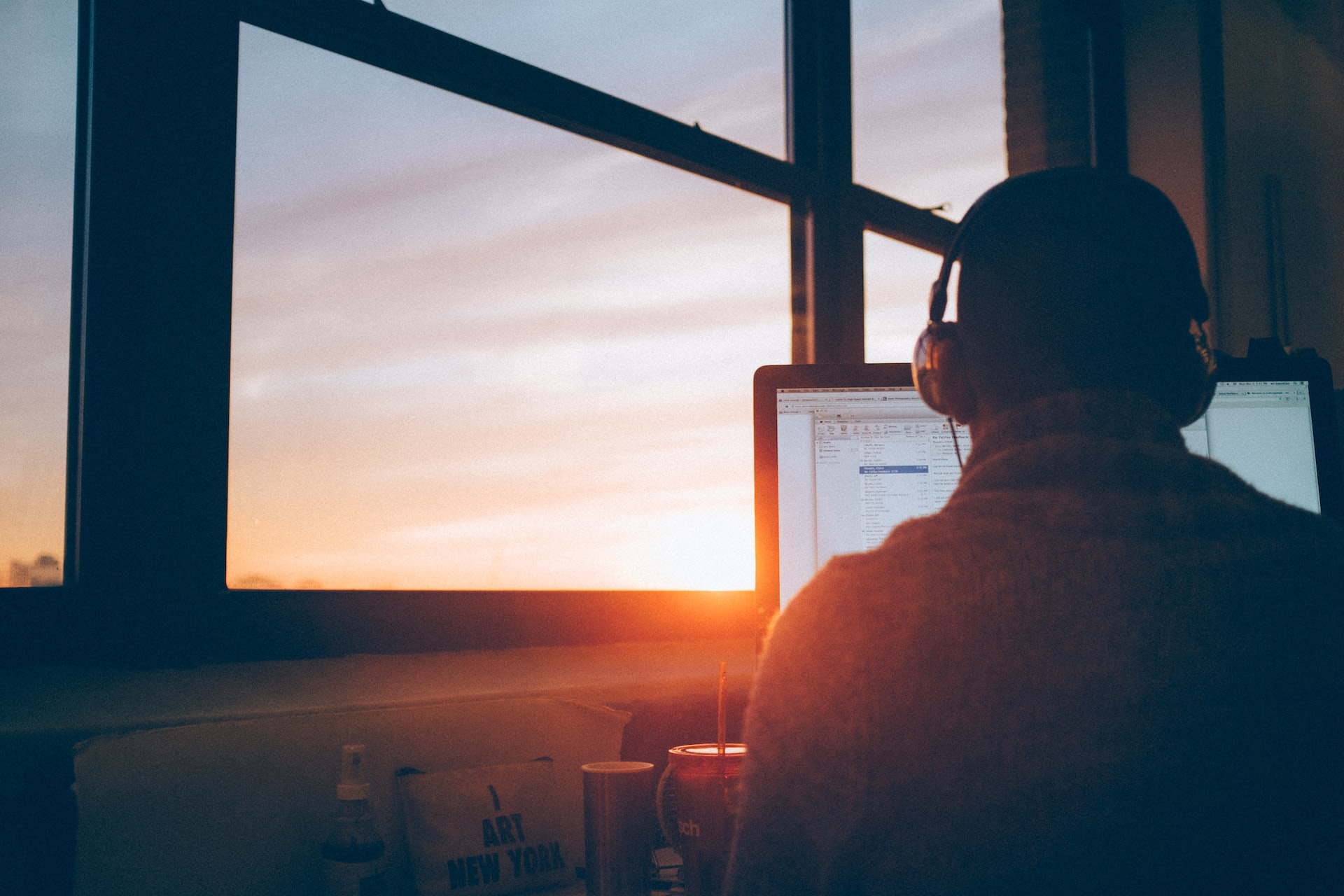 Worker on a computer with a sunset in the back